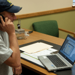 Détaillant John Deere au téléphone devant ordinateur
