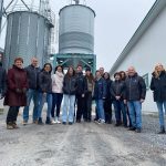 Les ministres Guilbault et Bibeau à l'extrême gauche ainsi que la ministre Caron à droite, entourés des gens de la Ferme Roflamme et divers invités.