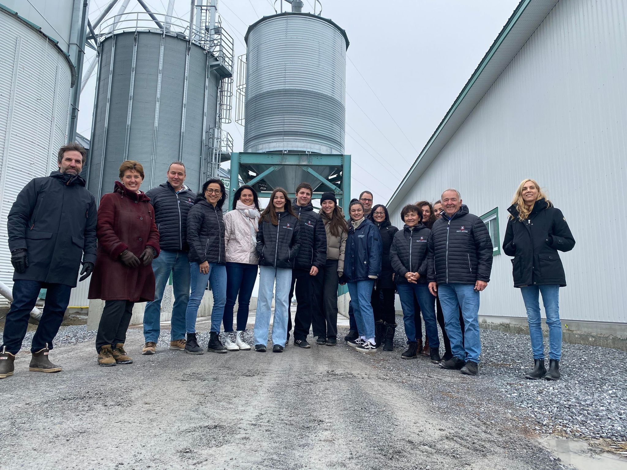 Les ministres Guilbault et Bibeau à l'extrême gauche ainsi que la ministre Caron à droite, entourés des gens de la Ferme Roflamme et divers invités.